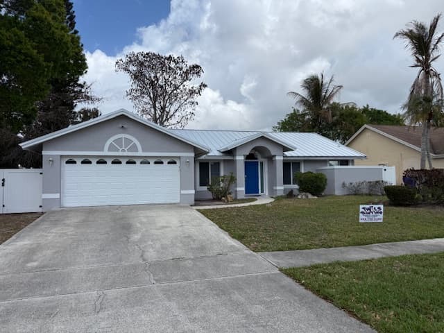 Gray South Florida home with a blue front door after painting by Twils Painting